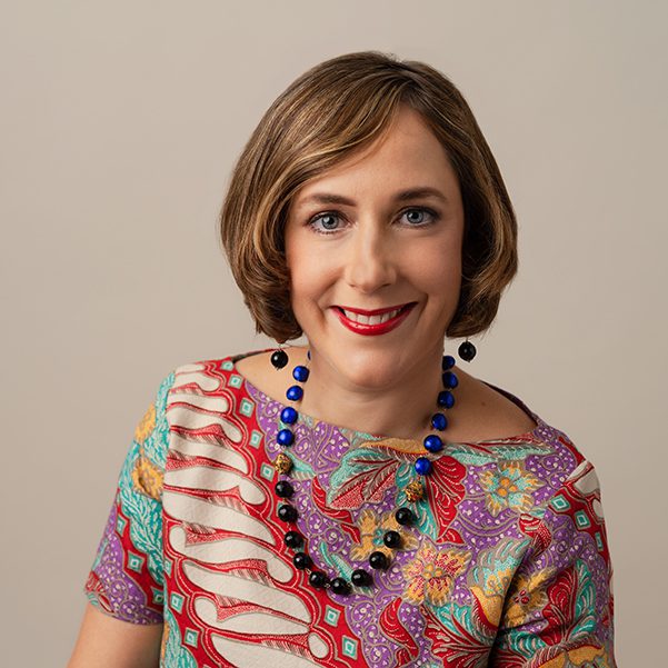 headshot of white woman in colourful top